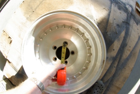 1995 Ford Bronco - A measuring tape is held against a silver wheel, likely for size verification.