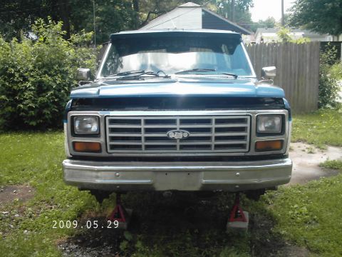 1986 Ford Bronco - Front view of a blue SUV, possibly a Ford Bronco, with its front end raised on jack stands.