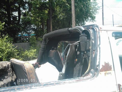 1986 Ford Bronco - The interior of a white SUV shows worn seats and a prominent roll bar, with a date stamp of 2009.05.29 visible.
