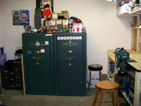 1995 Mercury Grand Marquis - Two large gun safes stand next to a workbench equipped with vises and tools, suggesting a workshop environment.