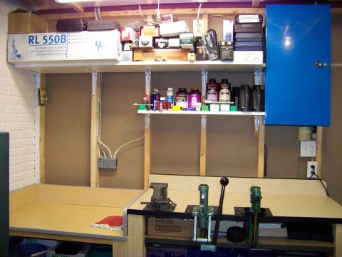 1995 Mercury Grand Marquis - Workbench setup with reloading equipment and various supplies stored on shelves above.