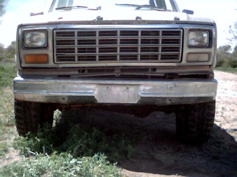 1981 Ford Bronco - The front end of a classic Ford F-Series truck is shown, its distinctive grille and bumper.