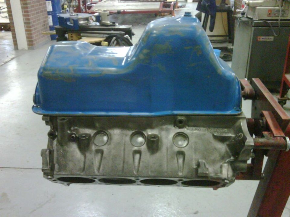 Engine block and blue oil pan on a stand
