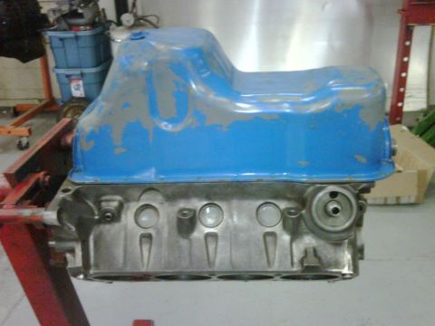 1996 Ford Bronco - Engine block and oil pan assembly on a stand in a workshop.
