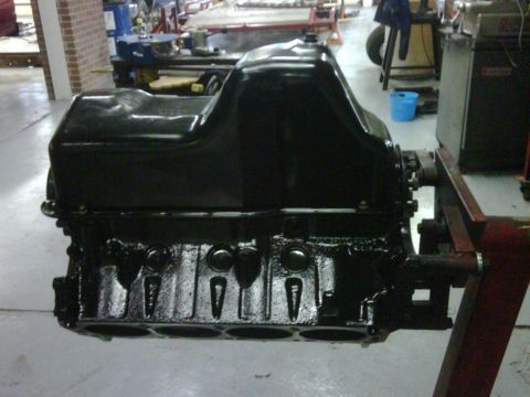 1996 Ford Bronco - Engine block and oil pan assembly on a stand in a workshop.