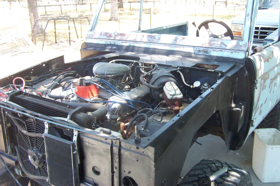 1976 Ford Bronco engine bay with exposed engine, radiator, and fan