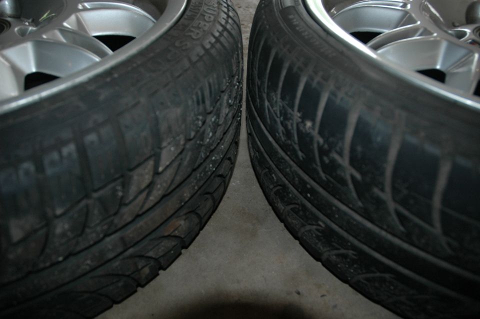 Close-up of two tires on silver alloy wheels showing tread patterns