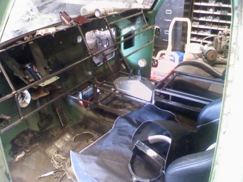 1979 Ford Bronco - Interior of a vehicle being rebuilt, showing exposed metal framework and seats.
