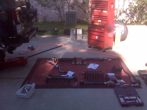 2008 Jeep Wrangler - Suspension components are laid out on a mat for a vehicle repair or upgrade project.