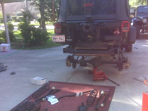 2008 Jeep Wrangler - The rear suspension components of a Jeep Wrangler have been removed and laid out on the ground for maintenance or modification.