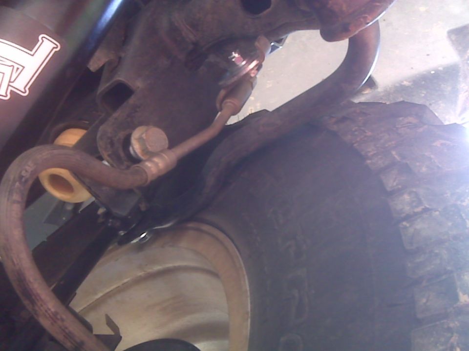 Close-up of Jeep suspension components, including a brake line and part of a tire