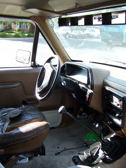 1991 Ford Bronco - Interior view of a Ford Bronco, likely from the late 1980s, with worn seats and a manual transmission.