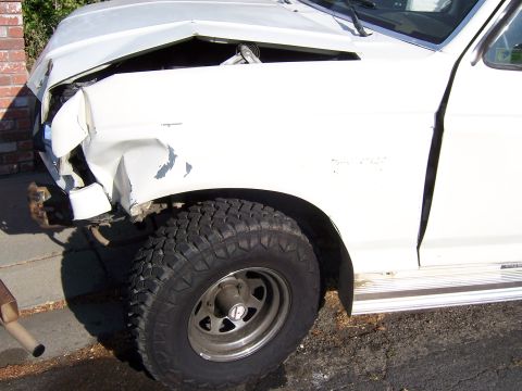 1991 Ford Bronco - This white SUV has significant damage to its front end, affecting the fender and hood area.