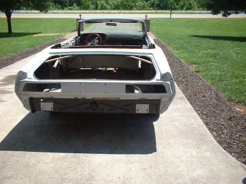 1970 Ford Torino - The rear of a white convertible car body is shown, with the trunk open and interior stripped down.