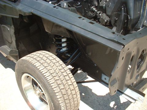 1970 Ford Torino - Close-up view of the front wheel well and suspension system of a vehicle, showing the tire and shock absorber.