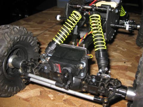 2010 Ford Pickup - Close-up of a remote control car's suspension system, showing shocks and steering servo.