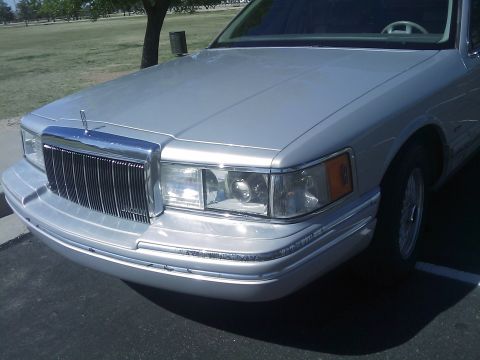 1992 Lincoln Town Car - The front quarter of a silver Lincoln Town Car is shown, its distinctive grille and headlights.