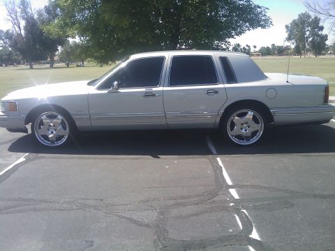 1992 Lincoln Town Car - A silver sedan with tinted windows and chrome wheels is shown from the side.
