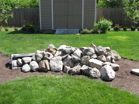 2010 Ford Pickup - A collection of large stones is arranged on the ground in a backyard setting.