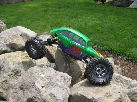 2010 Ford Pickup - A green remote control rock crawler navigates a rocky terrain with a grassy background.