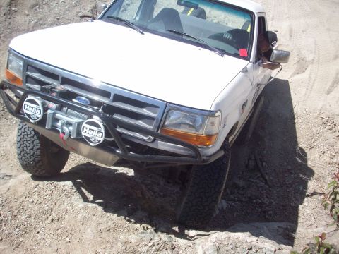 1995 Ford Bronco - White 1995 Ford Bronco navigating a rocky off-road course.