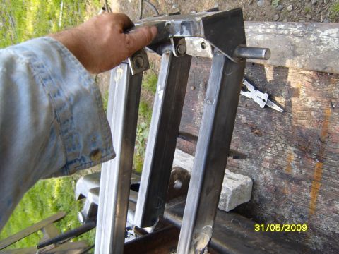 1989 Ford Bronco - Fabricated metal part being held by a hand, with tools visible in the background.