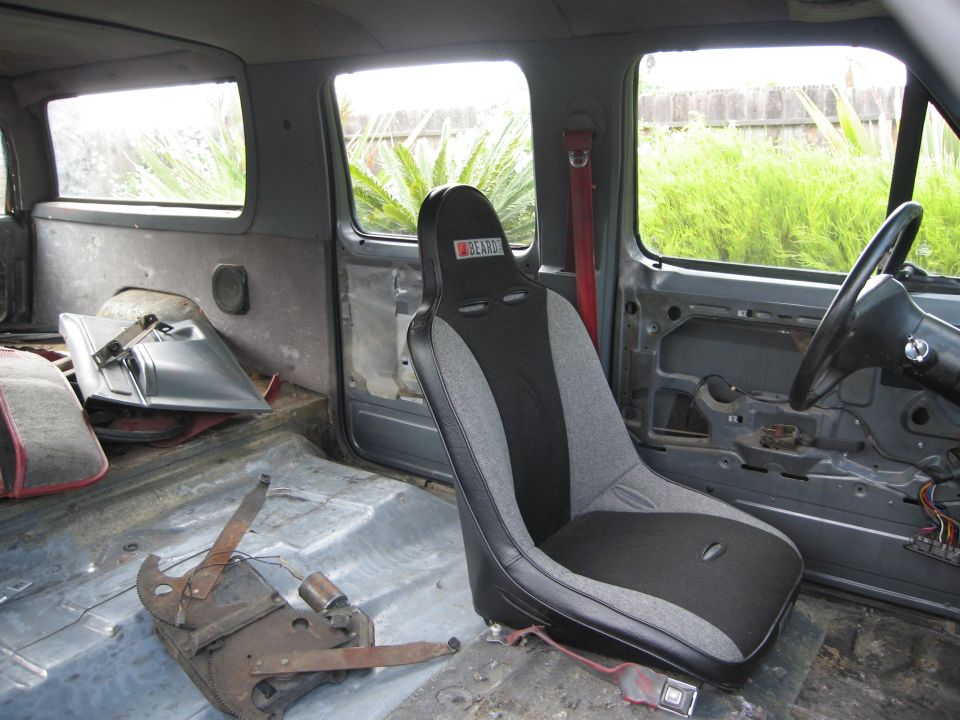 1986 Ford Bronco interior showing a racing seat and bare floor