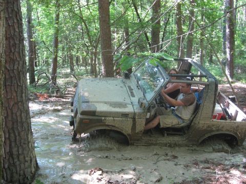 1987 Suzuki Samurai - This 1987 Suzuki Samurai is stuck deep in the mud while off-roading through a wooded area.