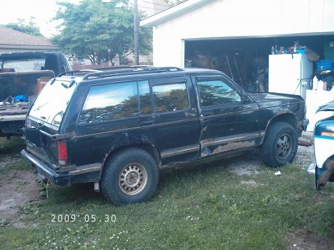 1994 GMC Jimmy - This black SUV is parked in a yard with a garage in the background. A date stamp shows 2009:05:30.