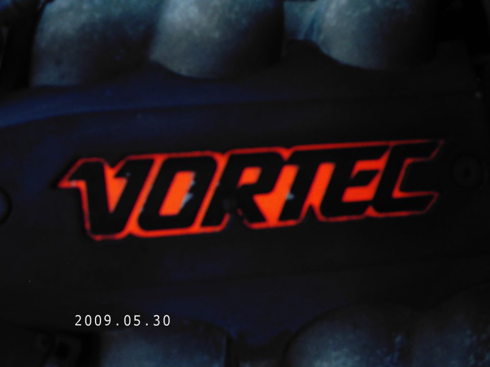 Black engine cover with orange 'Vortec' lettering and a date stamp '2009.05.30'