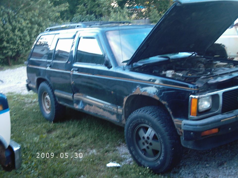 1994 GMC Jimmy SUV with hood open, parked on grass