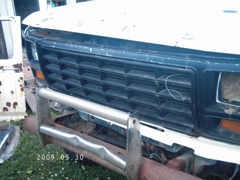 1986 Ford Bronco - Close-up view of a weathered Ford truck grille and a dented chrome bumper, with a date stamp of 2009.05.30.