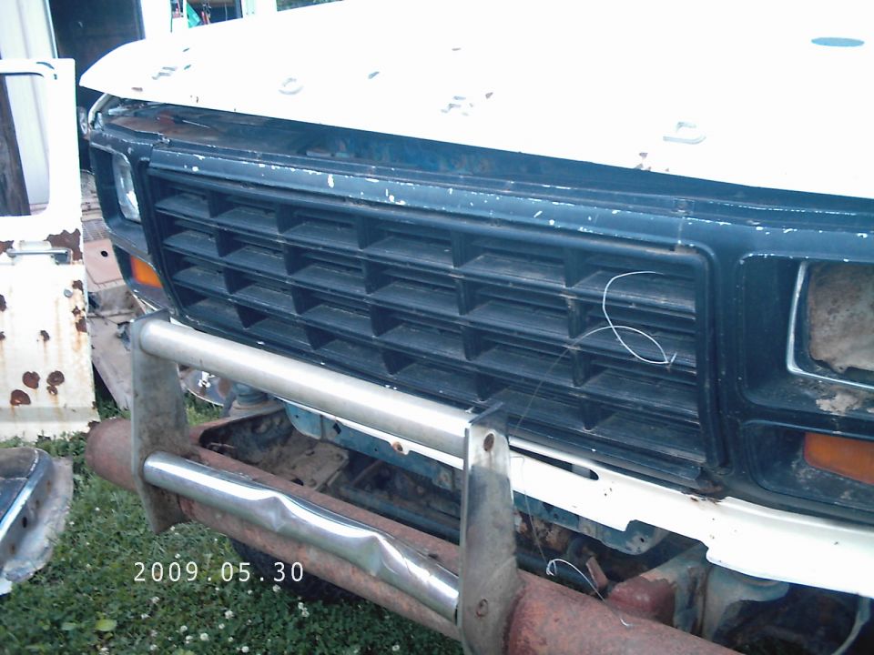 Front grille and bumper of an older Ford truck, possibly from the early 1980s