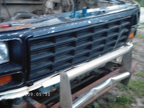 1986 Ford Bronco - Close-up of a dark grille and chrome bumper on an older Ford truck, with visible signs of age and use.
