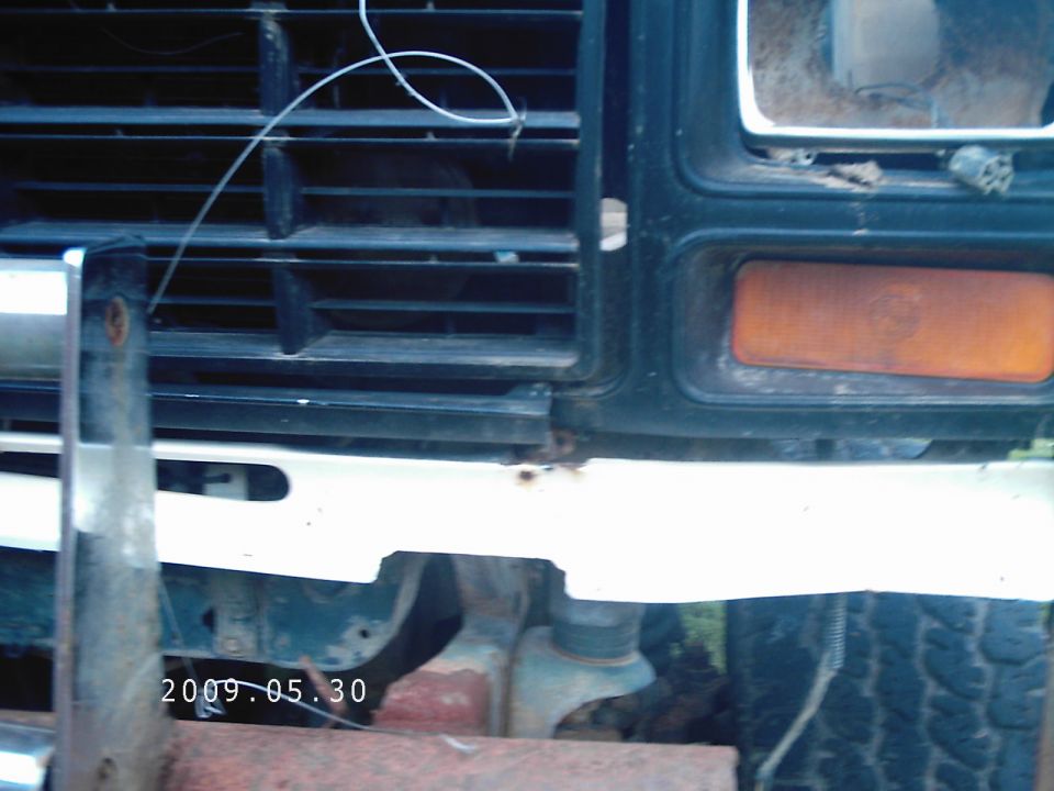 Front grille and bumper of a 1980s Ford Bronco, showing rust and dirt