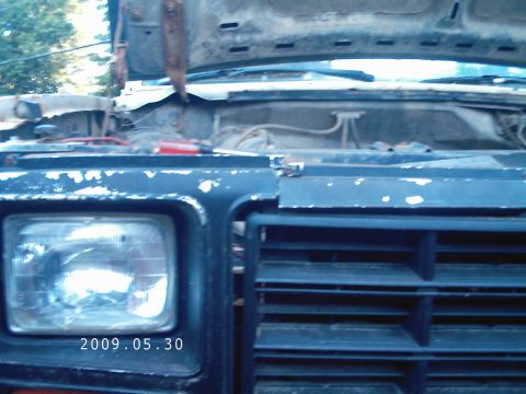 1986 Ford Bronco - The front of a dark blue vehicle is shown with the hood open, revealing the engine compartment. The date 2009.05.30 is visible on the headl…