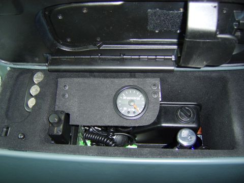 1996 Mercury Grand Marquis - A round vacuum gauge reading in inches of mercury (marked 20, VACUUM, 30, In Hg) mounted on a black bracket inside an open center console s…