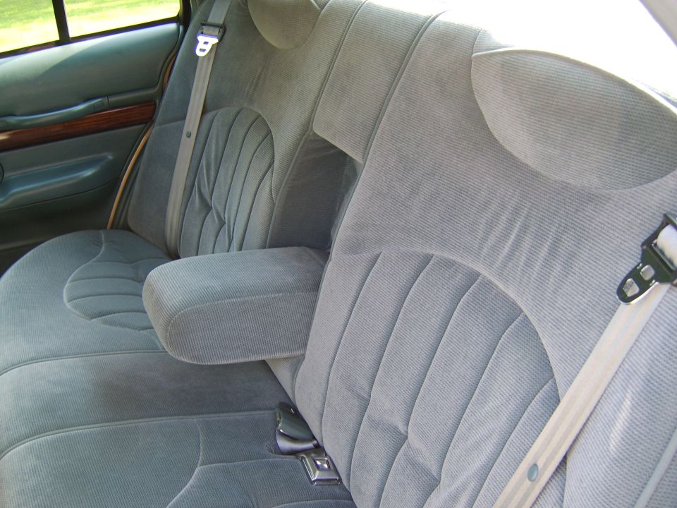 Gray cloth rear bench seat interior with seat belts and folding armrest