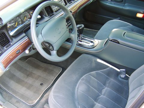 1996 Mercury Grand Marquis - gray cloth interior of a Mercury sedan with wood trim, a console shifter, and front bucket seats.