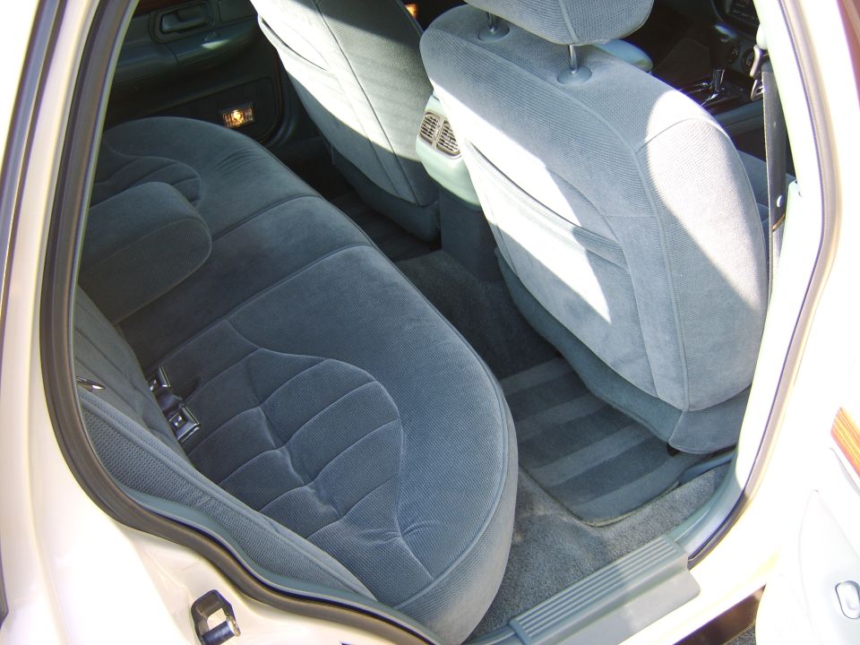 Gray cloth rear seat interior of a sedan viewed through the rear door