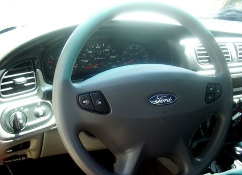 2000 Ford Taurus - The interior of a 2000 Ford Taurus, the steering wheel with Ford logo and the instrument cluster.