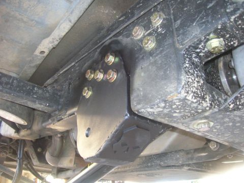 1996 Ford Bronco - Close-up view of a custom bracket attached to the vehicle's frame, indicating aftermarket suspension work.
