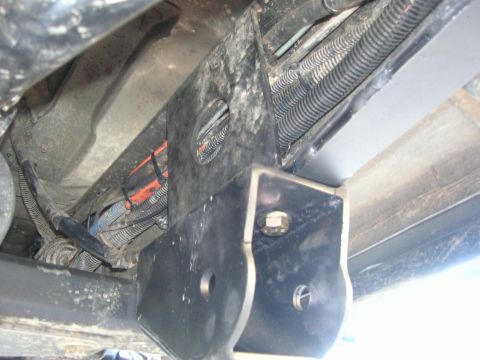 1996 Ford Bronco - Underside view of a vehicle's suspension bracket and associated wiring harnesses.