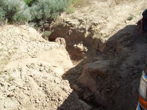1985 Ford Bronco - A vehicle is parked next to a large, excavated trench in a dry, outdoor environment.