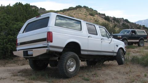 1996 Ford C-350 (Centurion Conversions) - White 1996 Ford C-350 Centurion Conversions parked on a dirt trail with another vehicle in the background.