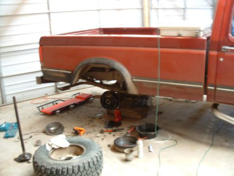 1988 Ford F-150 - Red Ford F-150 truck undergoing brake repair in a garage setting.