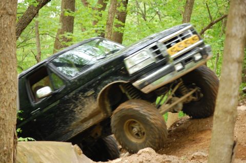1996 Ford Bronco - This Ford Bronco is navigating a challenging off-road course with steep inclines and rough terrain.