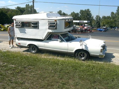 1970 Ford Ranchero - A white 1970 Ford Ranchero is equipped with a camper shell and parked by the roadside.