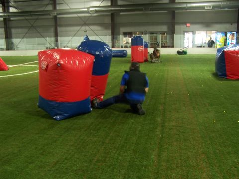 1986 Ford Bronco - An indoor paintball arena is set up with inflatable obstacles and players engaged in a game.