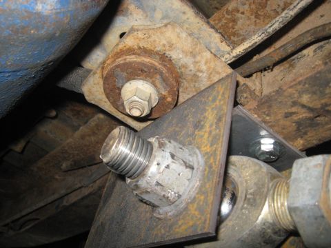 1978 Ford Bronco - Detail of a rusty bracket and fasteners on a vehicle's underside.